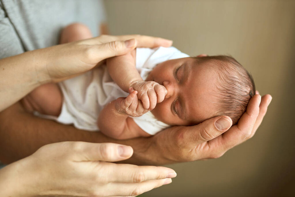 Ebeveynler yeni doğmuş bebek kafasını tutuyor. Annelik, babalık ya da ebeveynlik ve babalar günü konsepti. Modern ebeveynlik. Rahat ve güvenli bir uyku. İnsan sigortası. Aile mucizesi. - Fotoğraf, Görsel