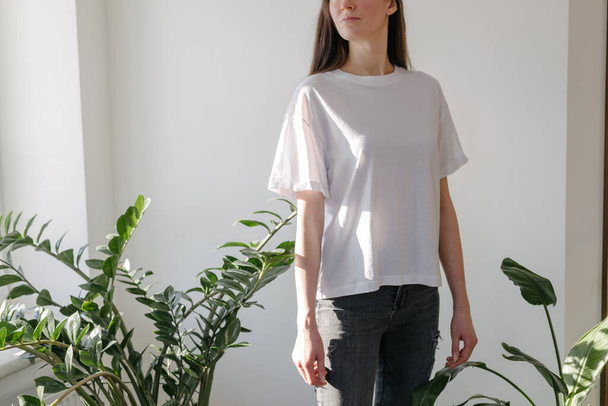 Woman wearing white blank t-shirt with space for your logo, mock up or design indoors - Foto, Bild