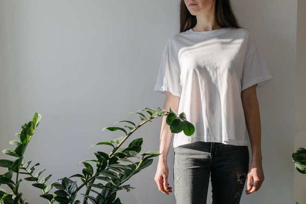 Woman wearing white blank t-shirt with space for your logo, mock up or design indoors - Valokuva, kuva