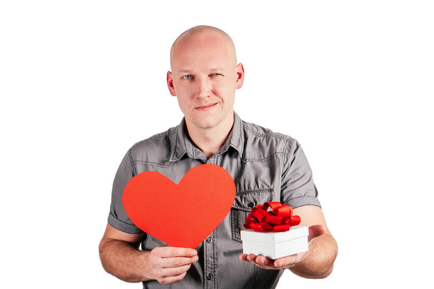 Smiling handsome bald middle-aged man hold big red paper heart and white gift box with red ribbon bow isolated on white - Photo, Image