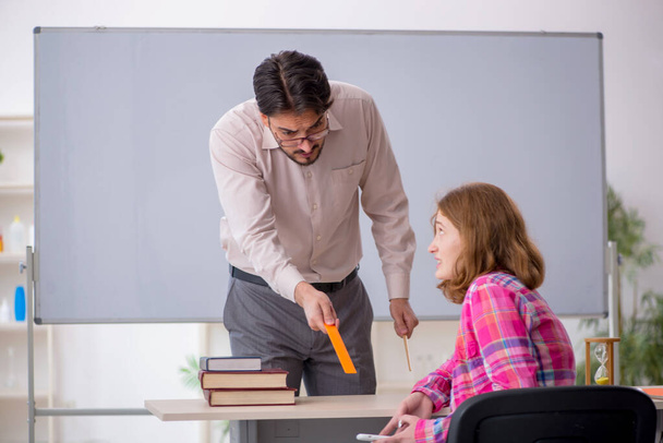 Young male teacher and redhead girl in the classroom - Φωτογραφία, εικόνα
