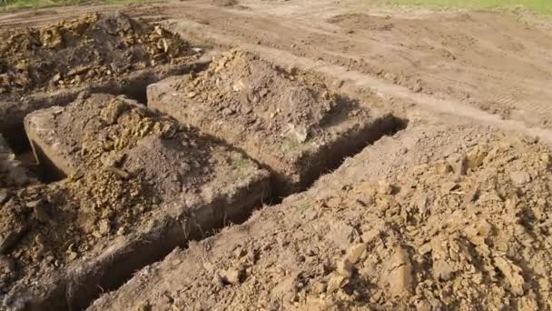 Uitgraven loopgraaf voor de bouw van nieuwe huis betonnen fundering op bouwplaats - Video