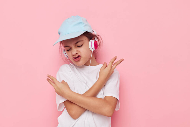 Portrait of happy smiling child girl listening to music on headphones isolated background - Foto, Imagen
