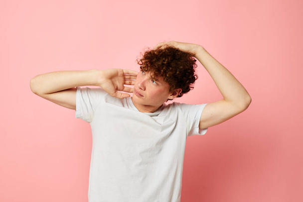 portrait of a young curly man posing youth style white t-shirt isolated background unaltered - Fotó, kép