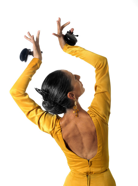 young Spanish woman dancing flamenco with castanets in her hands - Fotografie, Obrázek