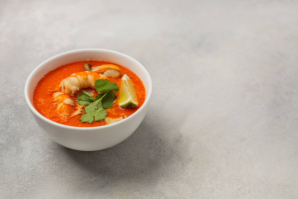 White bowl of fresh Tom Yum soup on a light background - 写真・画像