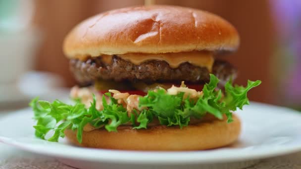 Rustikaler Hamburger mit geschmolzenem Käse und Rinderschnitzel. - Filmmaterial, Video