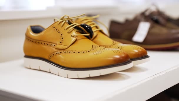 Mustard-colored leather men's boots in a shoe store. - Footage, Video