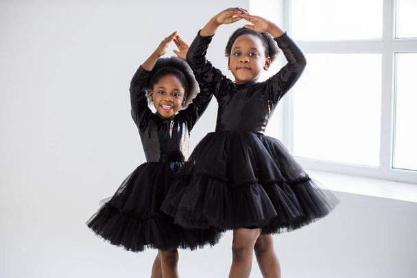 African little ladies in black dress dancing ballet indoors - Photo, Image
