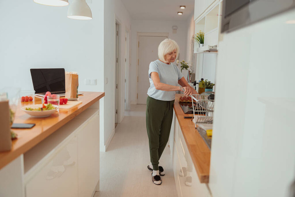 Starsza kobieta gotowania żywności w kuchni w domu - Zdjęcie, obraz