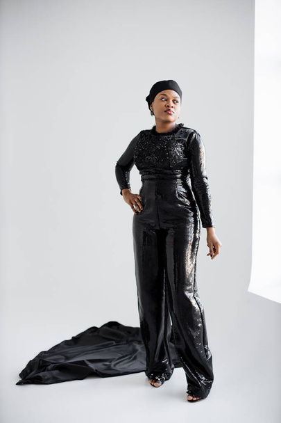 Mujer africana de moda en ropa de noche negra en interiores - Foto, imagen