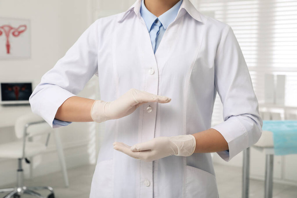 Young gynecologist holding something in modern clinic, closeup - Photo, Image