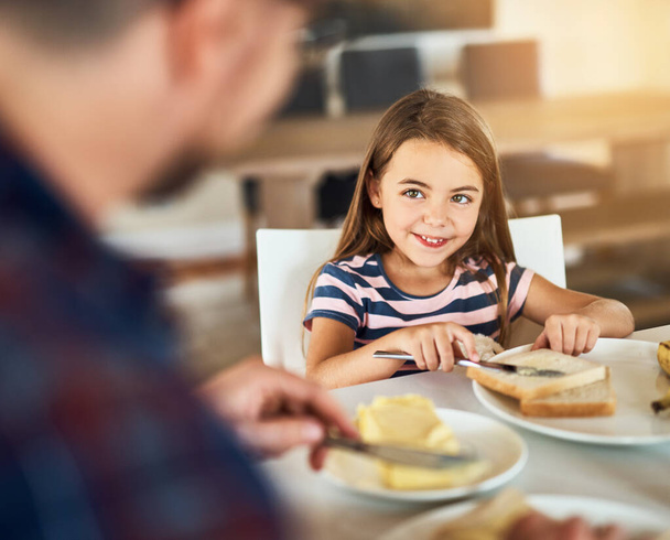 Ευχαριστώ για το πρωινό, μπαμπά. Μια φωτογραφία ενός αξιολάτρευτου κοριτσιού που τρώει πρωινό με τον πατέρα της στην κουζίνα.. - Φωτογραφία, εικόνα