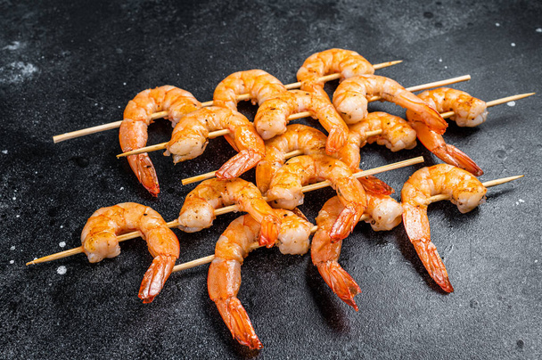 Grilled shrimps prawns on skewers with spices, herbs. Black background. Top view - Photo, Image