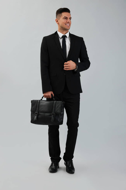 Businessman with stylish leather briefcase on light background - Фото, изображение