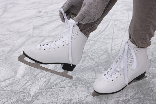 Woman lacing figure skates on ice, closeup - Foto, imagen