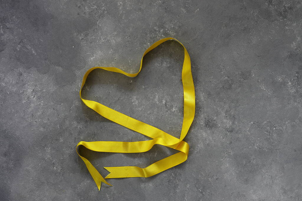 Valentines den srdce ve tvaru stuhy přes šedý dřevěný stůl - Fotografie, Obrázek