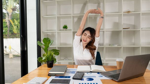 Azjatycka księgowa relaks Piękna azjatycka bizneswoman relaksuje mięśnie po siedzeniu przez długi czas wyczerpany z pracy. koncepcja zarządzania finansowego - Zdjęcie, obraz