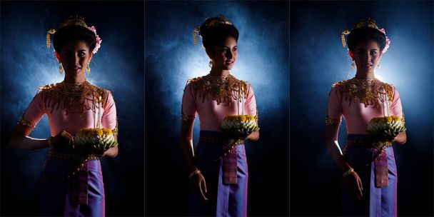 Loykrathong šaty thajské tradiční kostým nebo jihovýchodní Asie zlaté šaty v asijské ženy s dekorace stojan vyjádřit pocit šťastný úsměv na Loy Krathong plovoucí festival přes černé pozadí - Fotografie, Obrázek