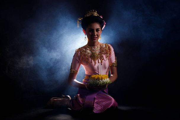 Лойкратонг сукня тайського традиційного костюму або золота сукня Південно-Східної Азії в азіатській жінці з орнаментом виражає радість для Лу Кратонг Плавальний фестиваль на чорному тлі. - Фото, зображення