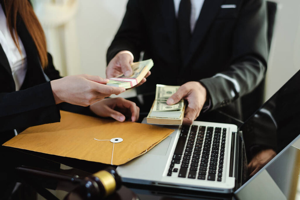 justice and law concept.passing bribe money in the envelop at lawyer office. - Foto, Imagen