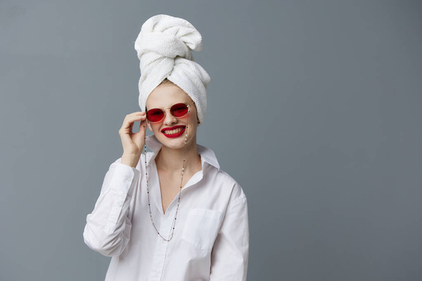 fashionable woman with a towel on his head in a white shirt Gray background - Photo, Image