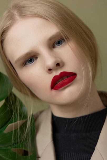 portrait of a woman red lips palm leaf charm fashion studio model unaltered - Photo, Image