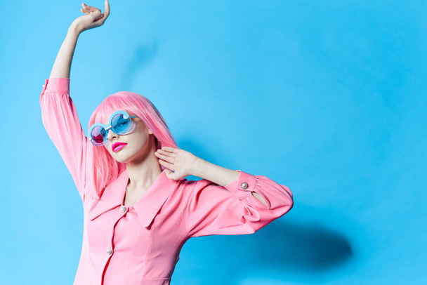 portrét ženy v modrých brýlích nosí růžovou paruku studio model beze změny - Fotografie, Obrázek