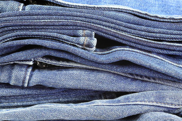 Stos dżinsów detal, wzór, faktura, tło płótna jeansowego. - Zdjęcie, obraz
