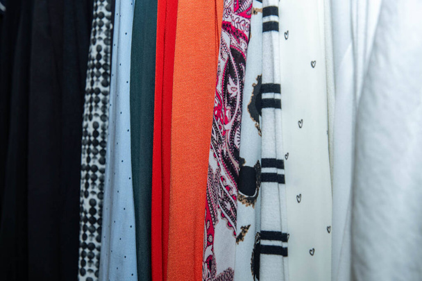 Ρούχα στοιβαγμένα σε διάφορα χρώματα στην ντουλάπα - Φωτογραφία, εικόνα