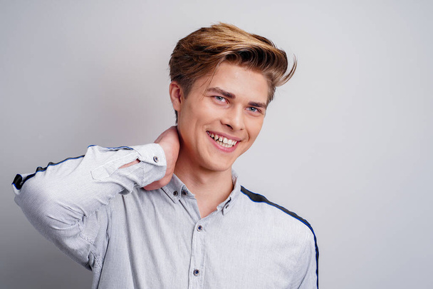 portrait of smiling hipster young guy wearing shirt while looking at camera. Stylish mans haircut - Фото, изображение