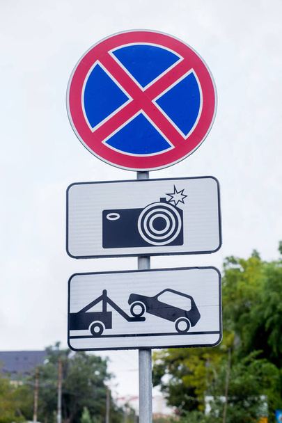 Traffic signs: car evacuation, no parking, surveillance camera. International traffic signs on a street. Transport and traffic infrastructure. - Фото, изображение