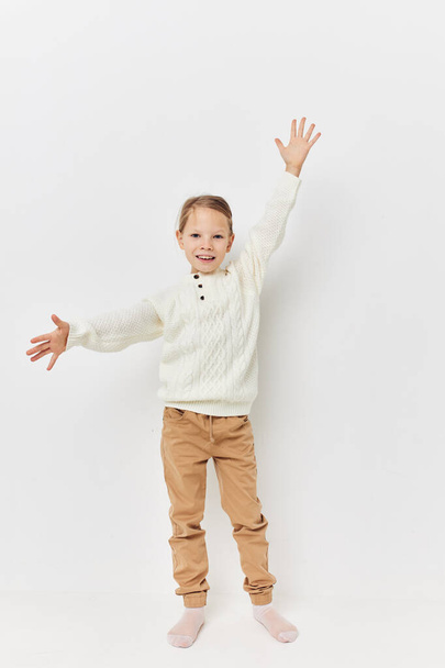 little girl in a white sweater stylish clothes light background - 写真・画像