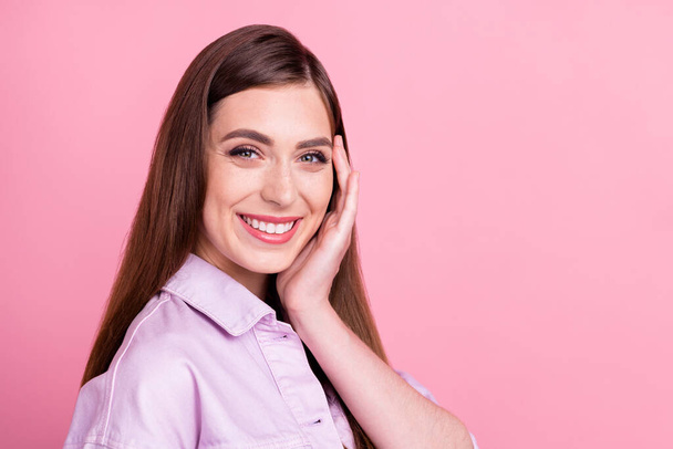 Foto retrato mujer sonriendo alegre tocando la cara después del tratamiento aislado pastel rosa color fondo copyspace - Foto, imagen