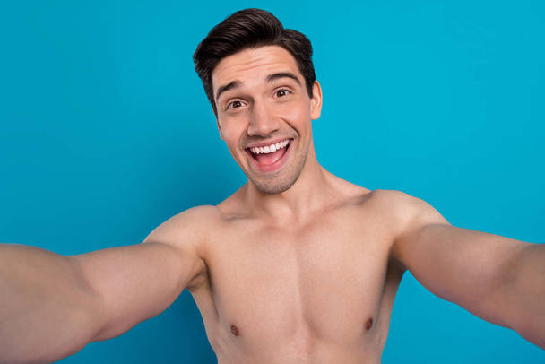 Photo of pretty excited young guy topless smiling recording self video isolated blue color background - Fotoğraf, Görsel