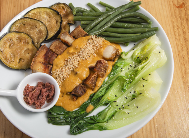 Knusprige Kare Kare, Schweinebauch sind Sauce mit Erdnüssen und Gemüse, philippinische Küche. - Foto, Bild