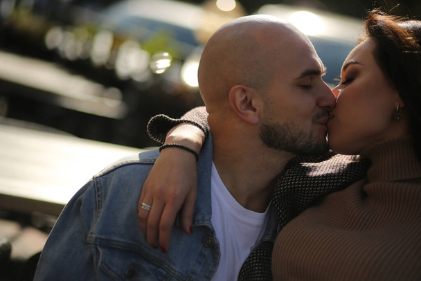  Close-up of a young beautiful couple kissing on the street. Feelings, love, relationships - Photo, Image