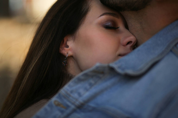  Gros plan d'une fille souriante aux yeux fermés embrassant un gars - Photo, image