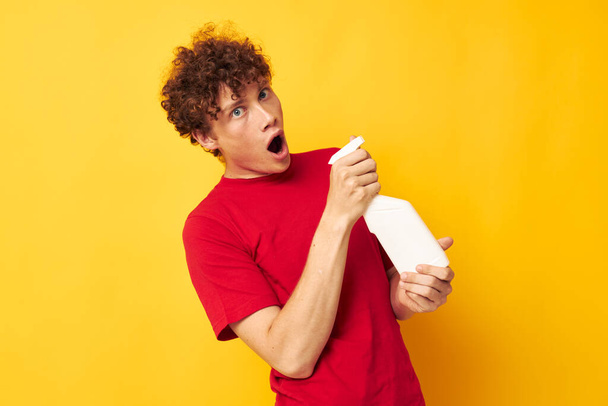 portrait of a young curly man detergents home care posing isolated background unaltered - Valokuva, kuva