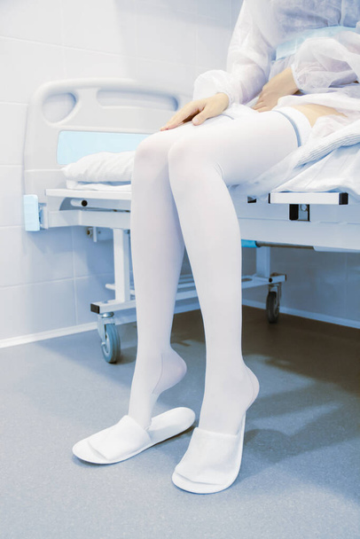 Anti-embolic surgery compression hosiery. Operating room in a hospital. Surgical equipment with operating table. Medical device for emergency patient in blue tone style. Clinic interior background - Foto, Bild