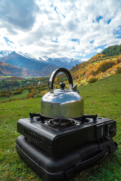 Cuisinière à gaz touristique avec une bouilloire haut avec un paysage de montagne incroyable par une journée ensoleillée d'automne. Cuisine du camp et thé. Photo verticale - Photo, image
