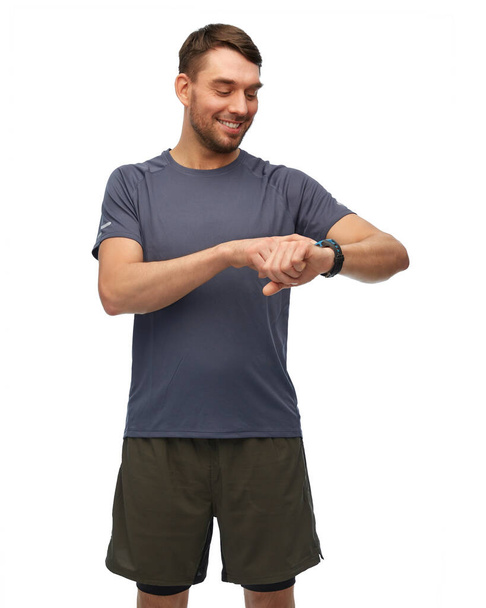 smiling man with smart watch or fitness tracker - Valokuva, kuva