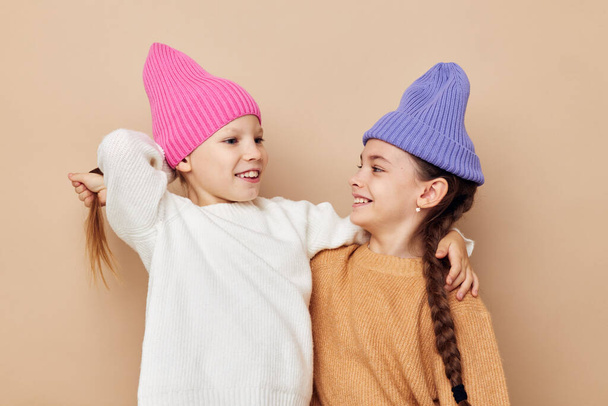 two funny girls hugging posing colorful hats - Foto, afbeelding