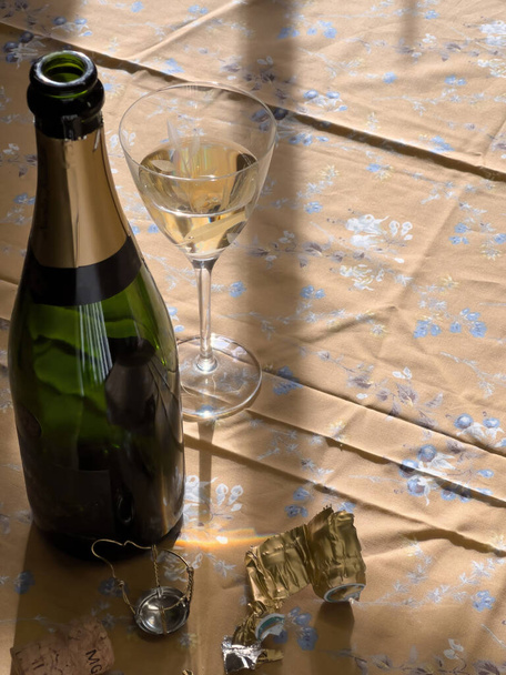 Servilleta de mesa de Navidad con copa de champán de cristal y botella cercana abierta durante las vacaciones de cumpleaños de Navidad de Año Nuevo - Foto, imagen