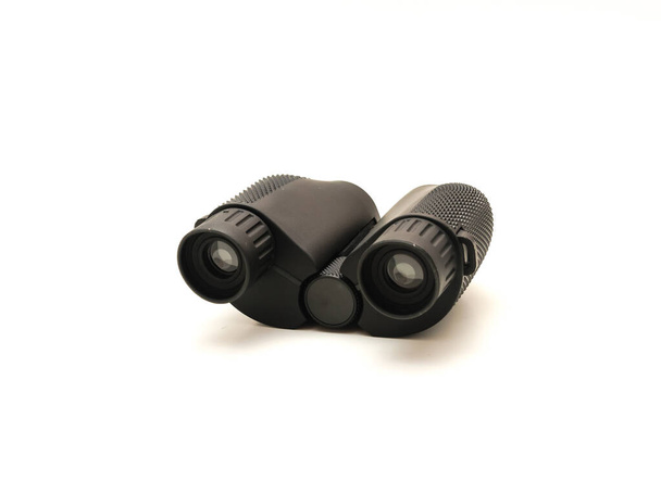 Multi-coated optics black compact Binoculars isolated on white background. Rugged rubber eye relief with glass surfaces zoom magnifying binoculars - Photo, Image
