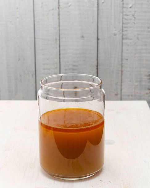homemade dark meat broth in a glass cup on a white background. - Photo, Image