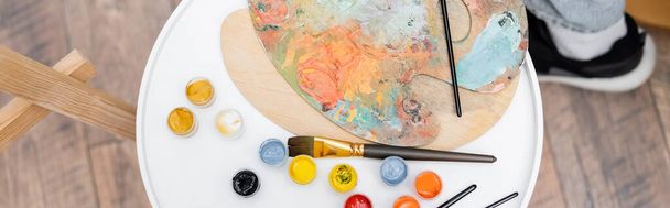 Top view paintbrushes near paints at home, banner  - Fotó, kép