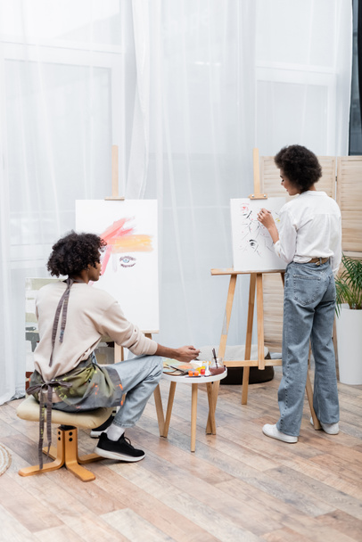 Giovane coppia afroamericana pittura su tele a casa  - Foto, immagini