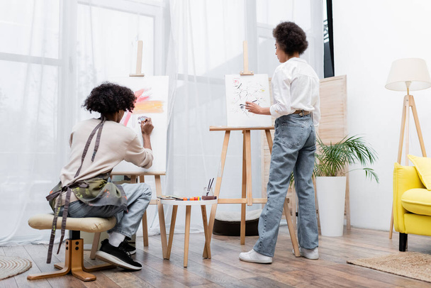 African american couple painting on canvases in living room  - Photo, Image