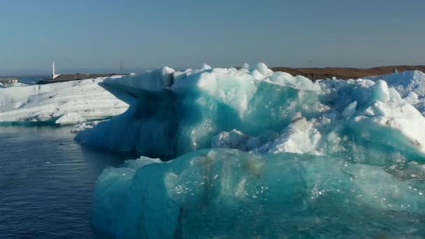 Slide i Pan materiał filmowy z kry lodowej pływających w arktycznym jeziorze lub rzece. Bloki niebieskiego lodu w zachodzącym słońcu. Islandia - Materiał filmowy, wideo
